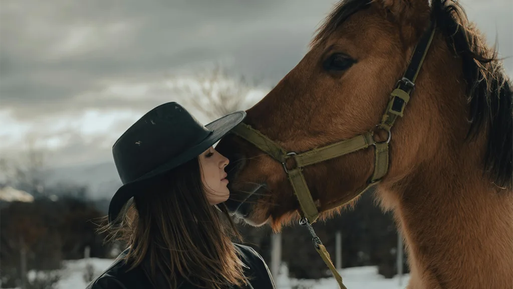 beste paardrijbroek voor de winter - op de foto: paard en vrouw die in de winter liefdevol poseren